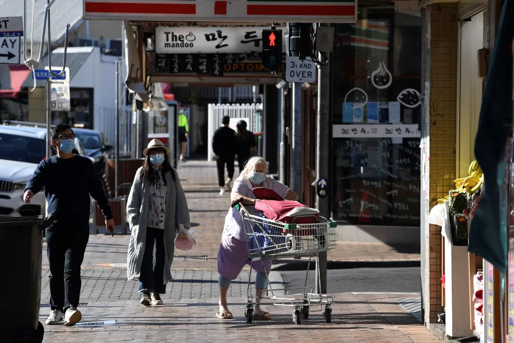 People wearing face masks walk through the quiet streets of the Strathfield suburb of Sydney on August 11, 2021, as the city's more than five million people are enduring their seventh week under stay-at-home orders. (Saeed Khan/AFP via Getty Images)
