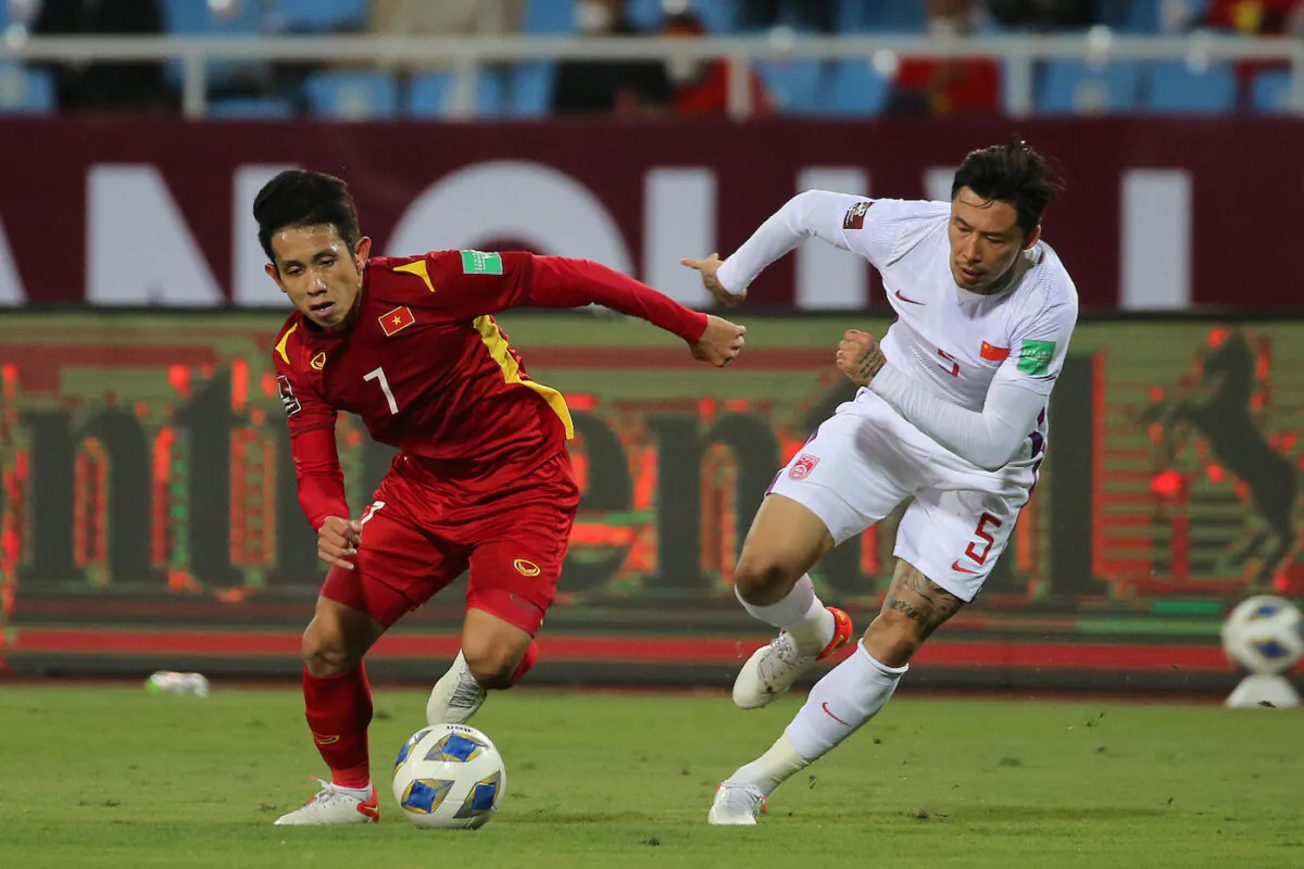 Vietnam player Nguyen Phong Hong Duy (L) fights for the ball with China's Zhang Linpeng (R) during the FIFA World Cup Asian Qualifier final round Group B match between Vietnam and China at My Dinh National Stadium in Hanoi, Vietnam, on Feb. 1, 2022. (Minh Hoang/Getty Images)
