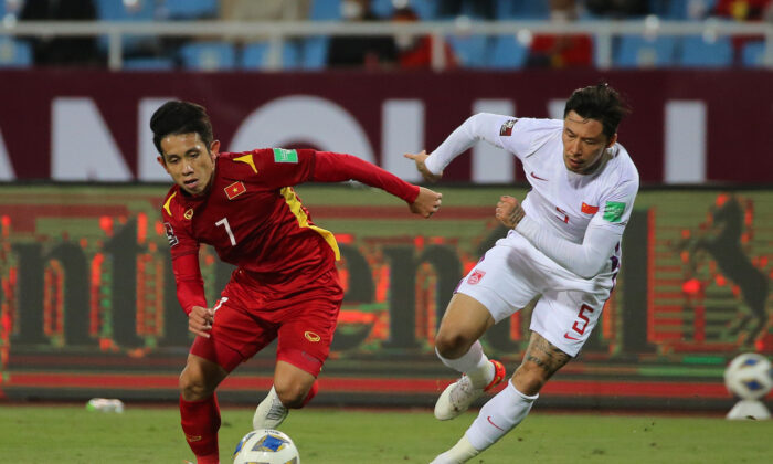 Vietnams Nguyen Phong Hong Duy (L) fights for the ball with Chinas Zhang Linpeng (R) during the FIFA World Cup Asian Qualifier final round Group B match between Vietnam and China at My Dinh National stadium in Hanoi, Vietnam on Feb. 1, 2022. (Minh Hoang/Getty Images)