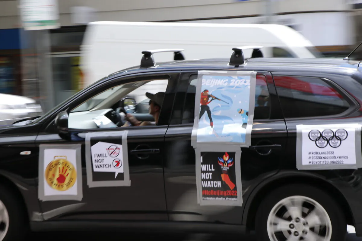 A car participating in the car parade to boycott the Beijing Olympic Games, blue poster on the car was designed by Chinese artist Badiucao, Melbourne, Australia, Feb. 4, 2022 (The Epoch Times)