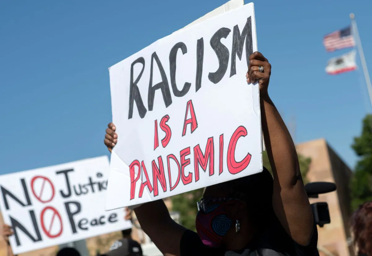 A woman holds up a placard during a protest in Victorville, Calif., on June 16, 2020. (Valerie Macon/AFP via Getty Images)