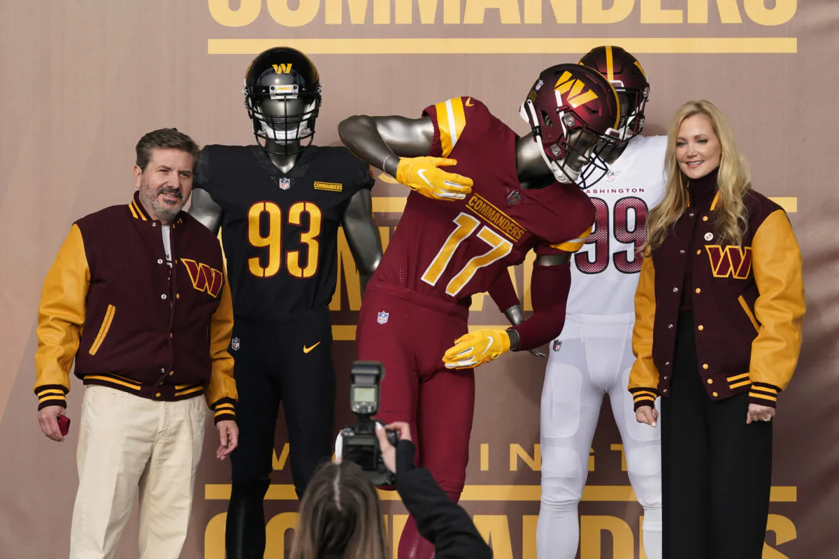Dan, left, and Tanya Snyder, co-owner and co-CEOs of the Washington Commanders, pose for photos after unveiling their NFL football team's new identity, in Landover, Md., on Feb. 2, 2022. (Patrick Semansky/AP Photo)