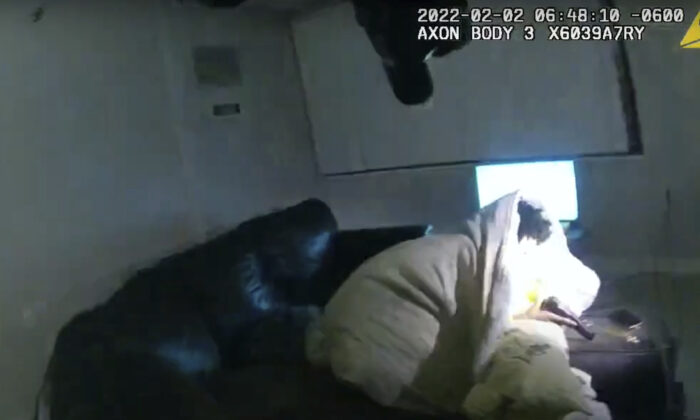 In this image taken from Minneapolis Police Department body camera video and released by the city of Minneapolis, 22-year-old Amir Locke wrapped in a blanket on a couch holding a gun moments before he was fatally shot by Minneapolis police as they were executing a search warrant in a homicide investigation in Minneapolis on Feb. 2, 2022. (Minneapolis Police Department via AP)