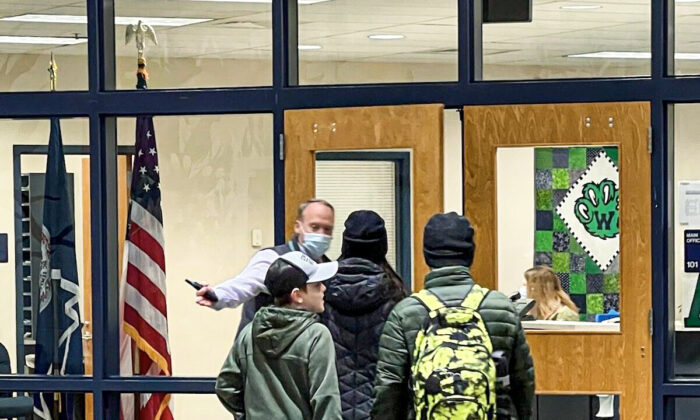 Principal William Shipp opens the door to direct unmasked students to the main office of Woodgrove High School in Purcellville, Va., on Feb. 2, 2022. (Courtesy of Erin Thomas)