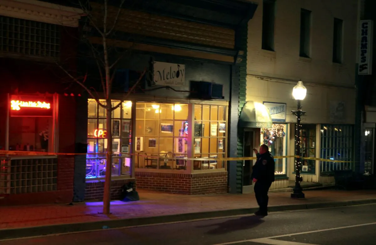 A police officer conducts an investigation after a shooting at a Melody Hookah Lounge on Main Street in Blacksburg, Va., on Feb. 5 2022. (Matt Gentry/The Roanoke Times via AP)