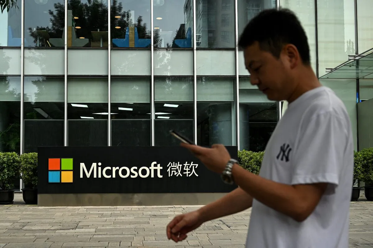 A man uses his mobile phone as he walks in front of Microsoft's local headquarters in Beijing on July 20, 2021. (Noel Celis/AFP via Getty Images)