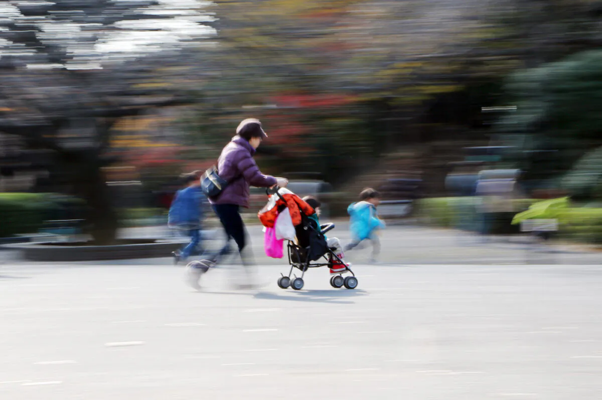 A file image of a woman with a pushchair walking with children at a park in Tokyo. (Yoshikazu Tsuno/AFP via Getty Images)