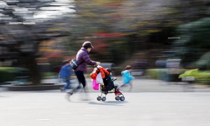 A file image of a woman with a pushchair walking with children at a park in Tokyo. (Yoshikazu Tsuno/AFP via Getty Images)