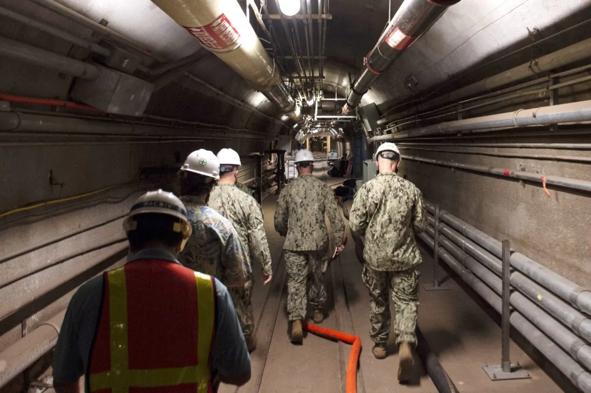 Rear Adm. John Korka, Commander, Naval Facilities Engineering Systems Command (NAVFAC), and Chief of Civil Engineers, leads Navy and civilian water quality recovery experts through the tunnels of the Red Hill Bulk Fuel Storage Facility, near Pearl Harbor, Hawaii, on Dec. 23, 2021. (Mass Communication Specialist 1st Class Luke McCall/U.S. Navy via AP)