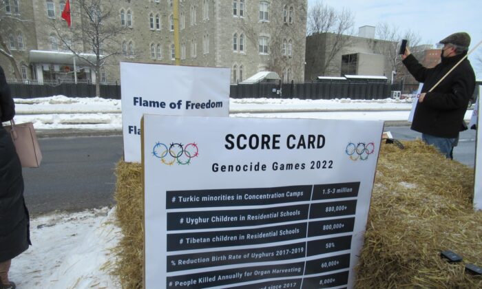 A score card that keeps track of the crimes against humanity committed by the Chinese regime is seen during the “Genocide Games” protest in front of the Chinese Embassy in Ottawa on Feb. 4, 2022. (Donna Ho/The Epoch Times)