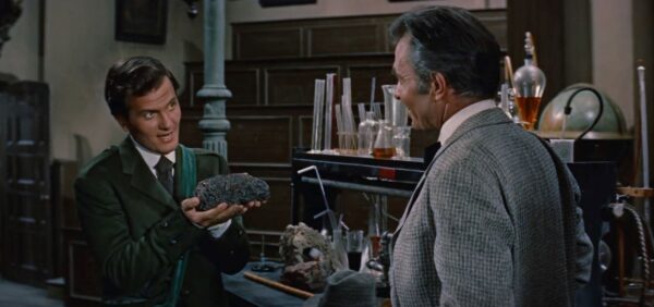 man holds rock to other man