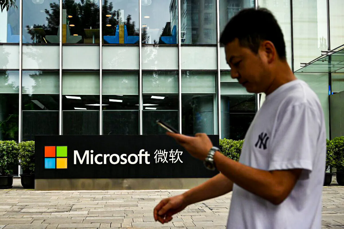 A man uses his mobile phone as he walks in front of Microsoft's local headquarters in Beijing on July 20, 2021. (Noel Celis/AFP via Getty Images)