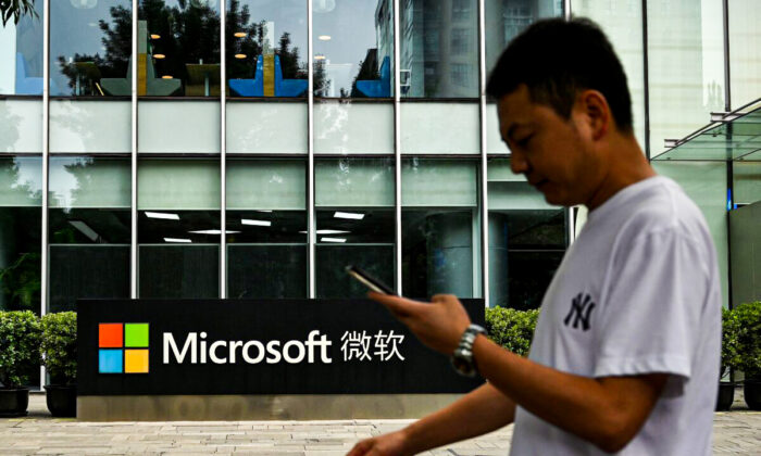 A man uses his mobile phone as he walks in front of Microsoft's local headquarters in Beijing, China, on July 20, 2021. (Noel Celis/AFP via Getty Images)
