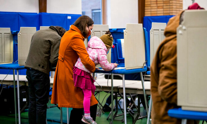 Minneapolis candidate for mayor Kate Knuth (L) fills out her ballot with her daughter, Maud Knuth at Bryn Mawr Community School on Election Day on Nov. 2, 2021. (Stephen Maturen/Getty Images)