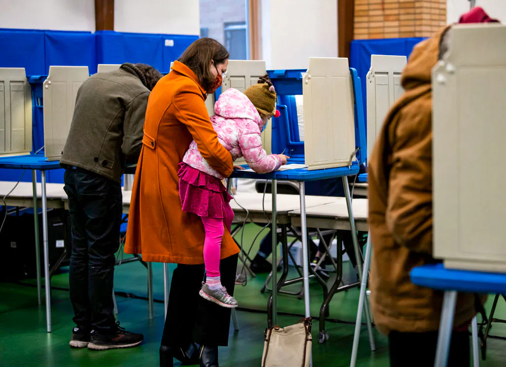 Minneapolis candidate for mayor Kate Knuth (L) fills out her ballot with her daughter, Maud Knuth at Bryn Mawr Community School on Election Day on Nov. 2, 2021. (Stephen Maturen/Getty Images)