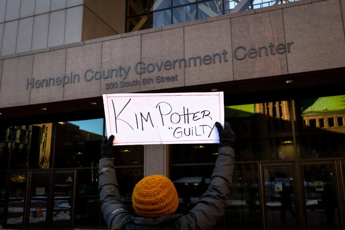 A local activist holds a sign at the Hennepin County Government Center in Minneapolis on Dec. 23, 2021. (Kerem Yucel/AFP via Getty Images)