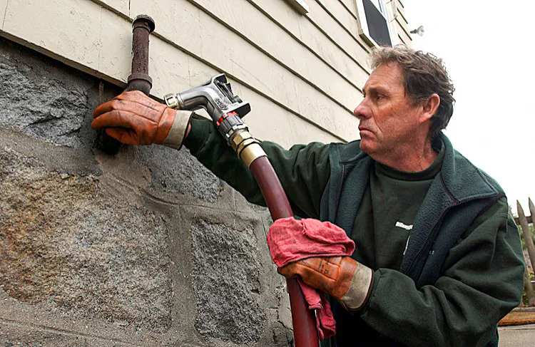 An employee with Hughes Oil makes a delivery in the West Roxbury neighborhood of Boston, Mass., in this file photo, taken on Nov. 24, 2004. (Darren McCollester/Getty Images)