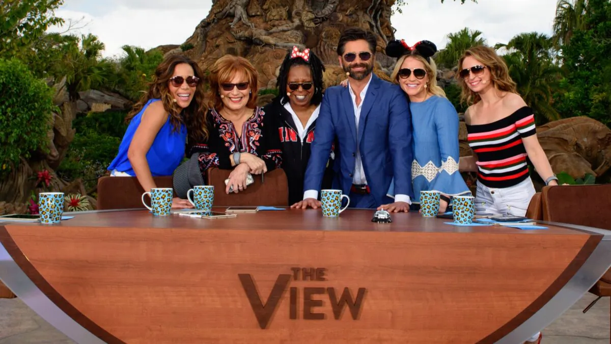 (L-R) In this handout photo provided by Disney Resorts, hosts Sunny Hostin, Joy Behar, Whoopi Goldberg, guest John Stamos, Sara Haines and Jedediah Bila pose on ABC's "The View" broadcasting from Disneys Animal Kingdom in Lake Buena Vista, Fla., on March 6, 2017. (Todd Anderson/Disney Resorts via Getty Images)