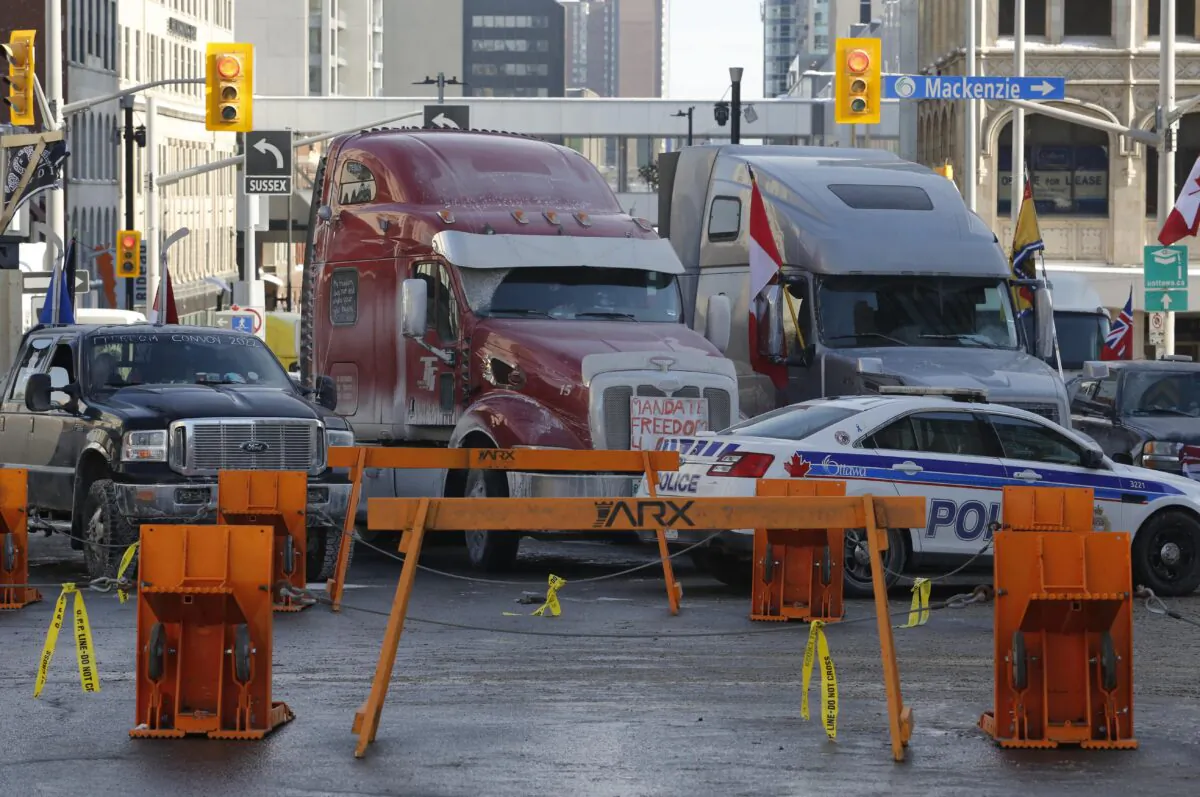 Trucks are blocked by police barricades as a rally against COVID-19 restrictions, which began as a cross-country convoy protesting a federal vaccine mandate for truckers continues in Ottawa on Feb. 1, 2022. (The Canadian Press/Patrick Doyle)