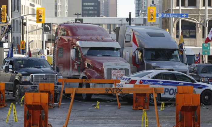 Trucks are blocked by police barricades as a rally against COVID-19 restrictions, which began as a cross-country convoy protesting a federal vaccine mandate for truckers continues in Ottawa on Feb. 1, 2022. (The Canadian Press/Patrick Doyle)