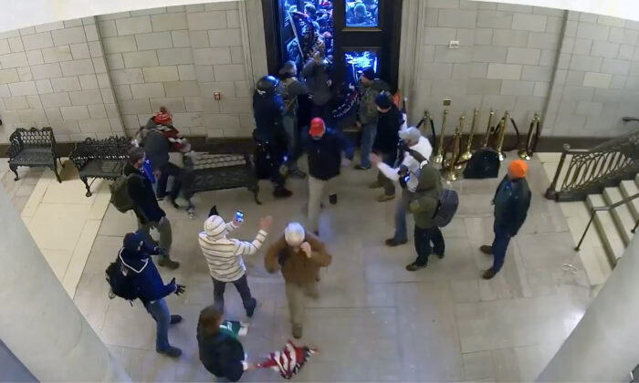 People flow into the Capitol Rotunda after being let in by a protester, shown on this surveillance video on Jan. 6, 2021. (U.S. Department of Justice/Screenshot via The Epoch Times)