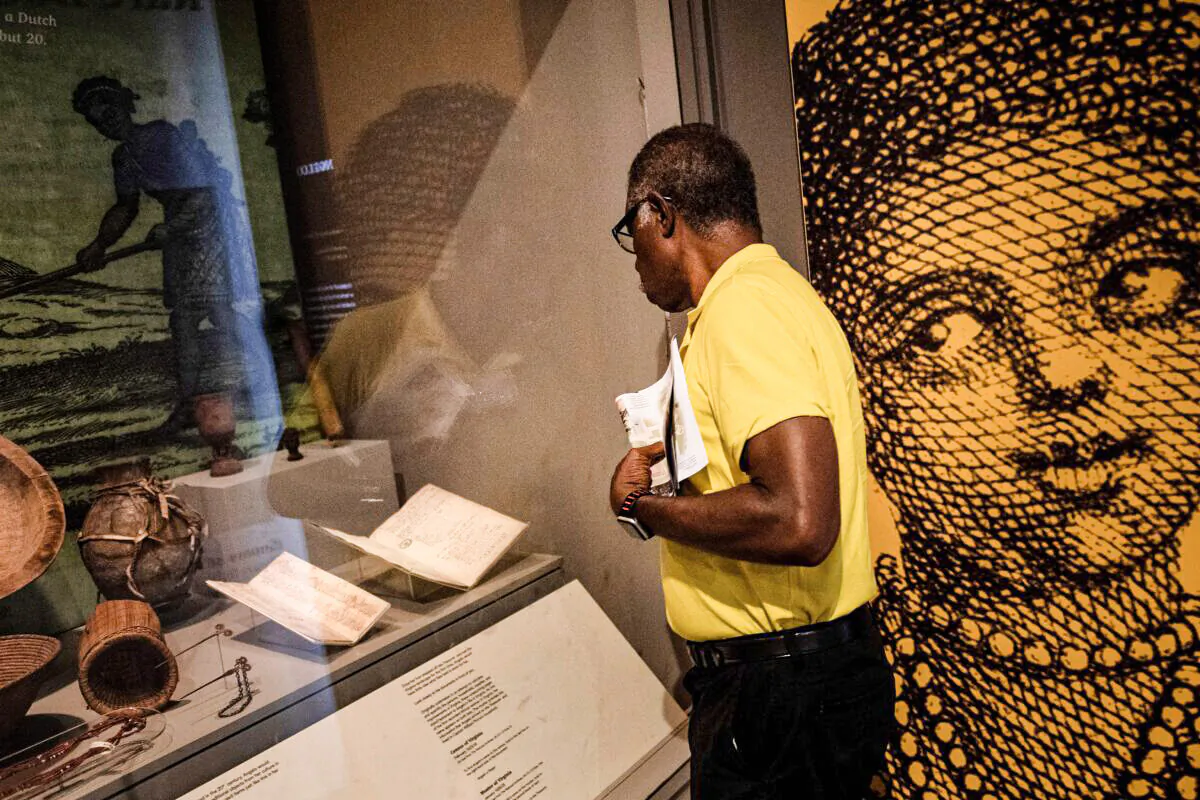 A man looks at a census and a muster of Virginia, which mentions the first documented African woman to arrive in the Virginia Colony in Williamsburg, Va., on Aug. 19, 2019. (Brendan Smialowski/AFP via Getty Images)