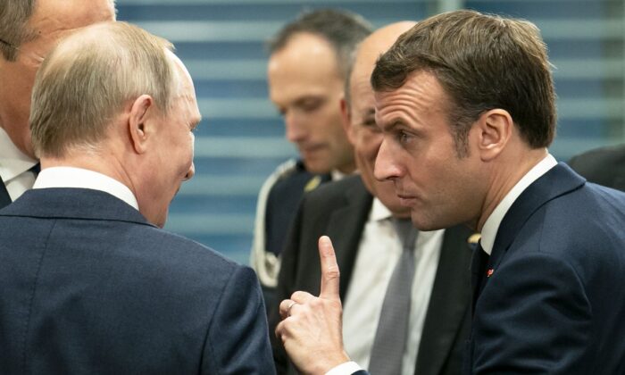 French President Emmanuel Macron (R) speaks with Russian President Vladimir Putin (L) before a meeting at the Chancellery in Berlin, Germany, on Jan. 19, 2020. (Emmanuele Contini/Getty Images)