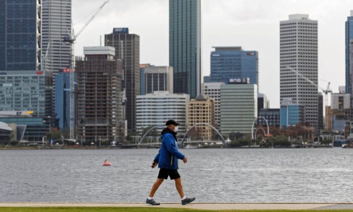 A man wearing a mask walks along the foreshore in Perth, Australia on Jun. 29, 2021. (Photo by TREVOR COLLENS/AFP via Getty Images)