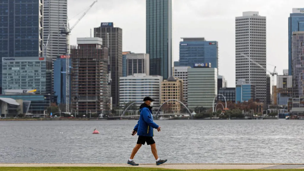 A man wearing a mask walks along the foreshore in Perth, Australia on Jun. 29, 2021. (Photo by TREVOR COLLENS/AFP via Getty Images)