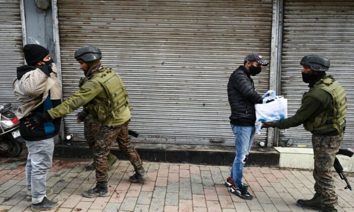 Indian government forces frisk pedestrians along a road in Srinagar on Jan. 25, 2022, after suspected militants threw a hand grenade towards government forces. (Tauseef Mustafa/AFP via Getty Images)