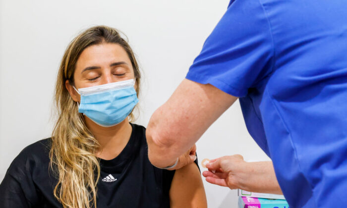 A woman closes her eyes after receiving a COVID-19 vaccine at Sydney Road Family Medical Practice in Balgowlah, in Sydney, Australia, on Jan. 10, 2022. (Jenny Evans/Getty Images)
