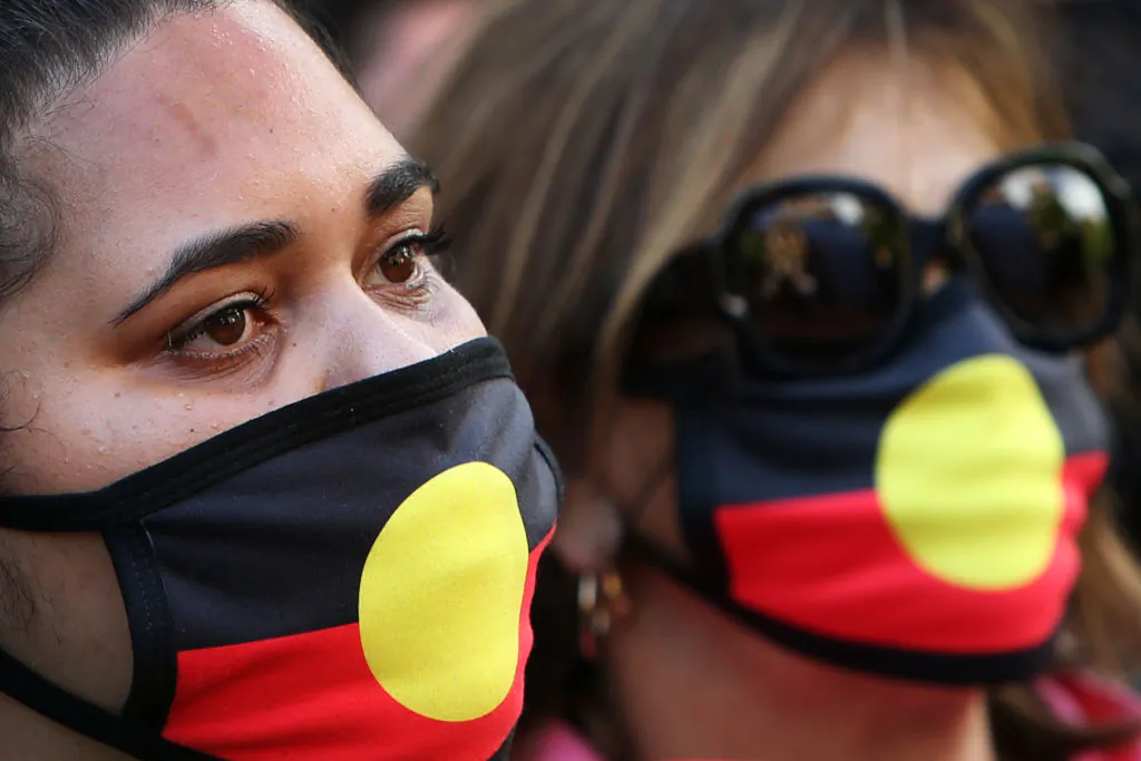 Indigenous activists wear face masks during an Invasion Day rally at Town Hall in Sydney, Australia, on Jan. 26, 2022. (Lisa Maree Williams/Getty Images)