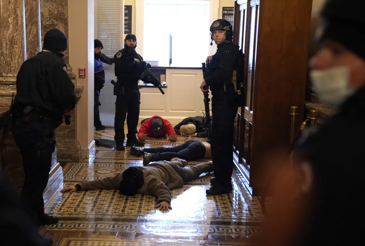 U.S. Capitol Police detain protesters outside of the House Chamber on Jan. 6, 2021. Nolan Cooke, 23, of Savoy, Texas, was one of the first to break through a line of U.S. Capitol police officers, according to court documents. Cooke pleaded guilty March 9 to a list of charges. (Drew Angerer/Getty Images)