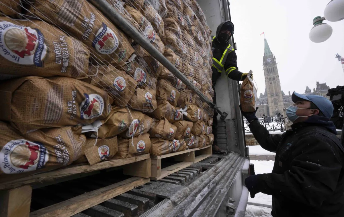 Bags of Prince Edward Island potatoes are unloaded from a transport truck, Dec. 8, 2021 in Ottawa. (The Canadian Press/Adrian Wyld)