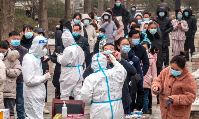 Residents queue to undergo nucleic acid tests for COVID-19 in Anyang in central China's Henan Province on Jan. 26, 2022. (STR/AFP via Getty Images)
