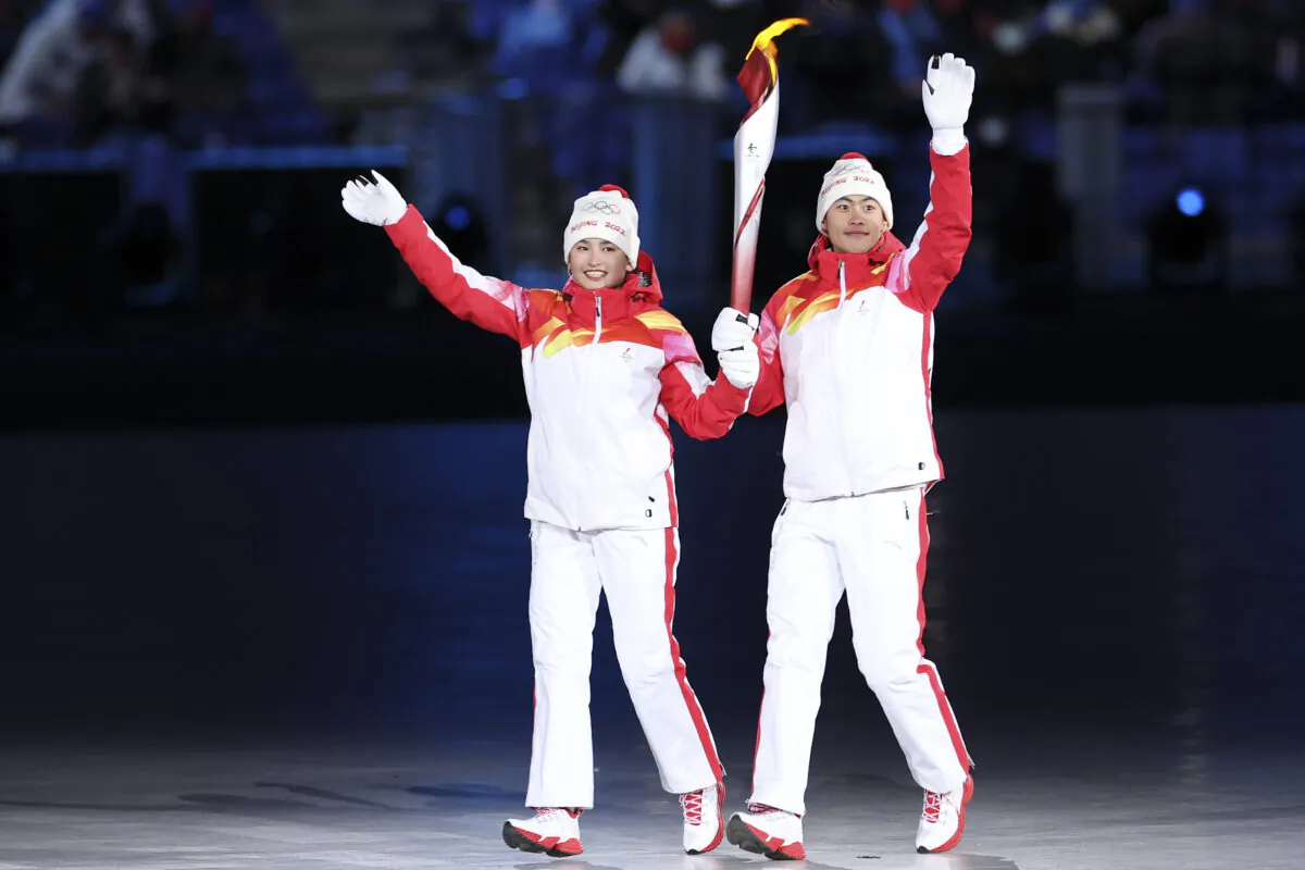 Chinese torchbearer athletes Dinigeer Yilamujian and Zhao Jiawen hold the Olympic flame during the opening ceremony of the 2022 Winter Olympic Games at the National Stadium in Beijing, China, on Feb. 04, 2022. (Lintao Zhang/Getty Images)