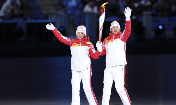 Chinese torchbearer athletes Dinigeer Yilamujian and Zhao Jiawen hold the Olympic flame during the opening ceremony of the 2022 Winter Olympic Games at the National Stadium in Beijing, China, on Feb. 4, 2022. (Lintao Zhang/Getty Images)