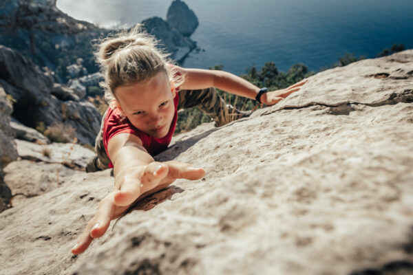 Brave,Young,Woman,Climber,Fearlessly,Climbs,Up,Sheer,Stone,Wall