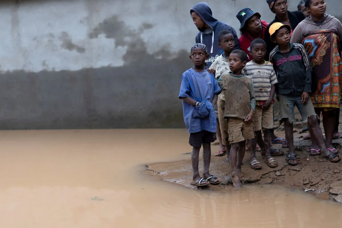 Locals stand next to a flooded area, as Cyclone Batsirai sweeps inland, in Fianarantsoa, Madagascar, on Feb. 6, 2022. (Alkis Konstantinidis/Reuters)