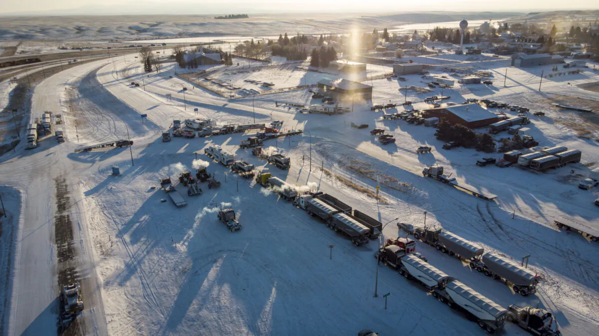Protesters demonstrating against COVID-19 mandates gather as a truck convoy blocks the highway at the U.S. border crossing in Coutts, Alta., on Feb. 2, 2022. (The Canadian Press/Jeff McIntosh)