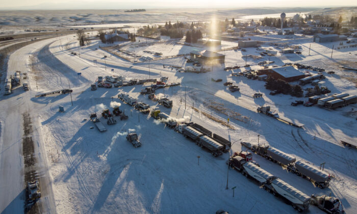 Protesters demonstrating against COVID-19 mandates gather as a truck convoy blocks the highway at the U.S. border crossing in Coutts, Alta., on Feb. 2, 2022. (The Canadian Press/Jeff McIntosh)