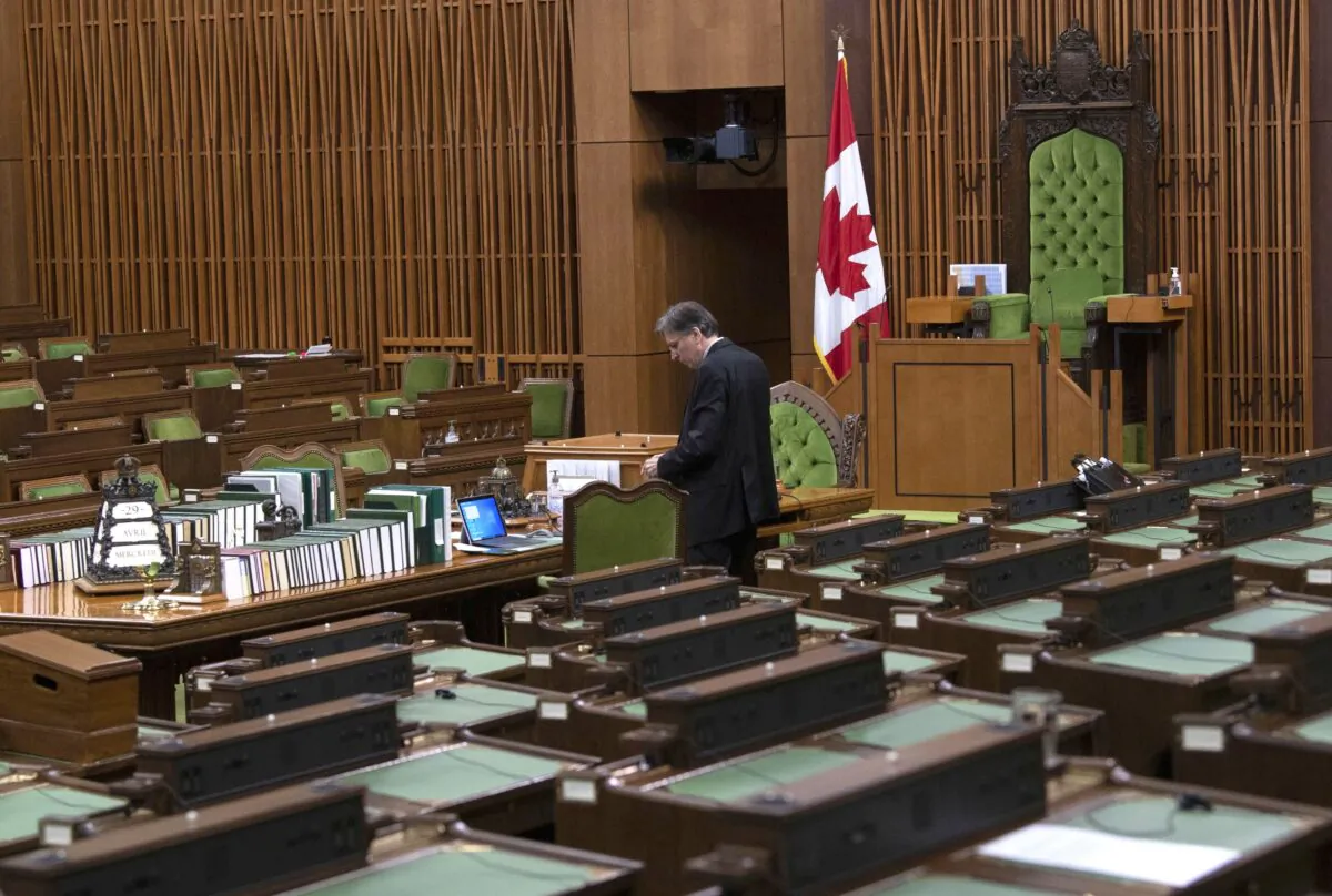 A clerk prepares for a committee meeting in the House of Commons chamber in Ottawa on April 29, 2020. (The Canadian Press/Adrian Wyld)