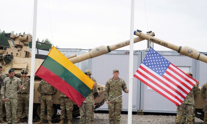 Soldiers hold Lithuanian and U.S. flags during the opening ceremony of the U.S. army camp Herkus, in Pabrade, Lithuania, on Aug. 30, 2021. (Janis Laizans/Reuters)
