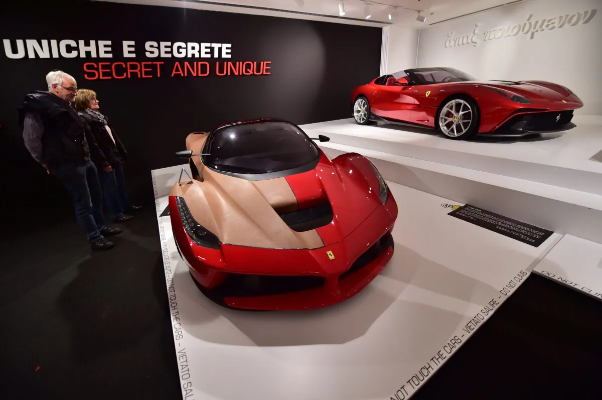 Visitors look at a Ferrari F12 TRS at the Ferrari Museum in Maranello, Italy, on Oct. 18, 2015. (Giuseppe Cacace/AFP via Getty Images)