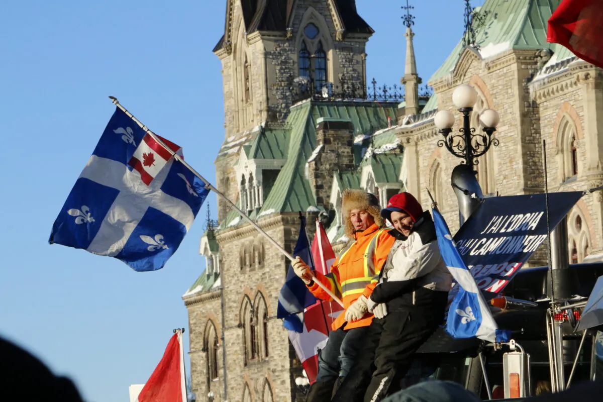 Protesters demanding the lifting of COVID-19 restrictions sit atop a truck in front of Parliament Hill in Ottawa on Feb. 5, 2022. (Noé Chartier/The Epoch Times)