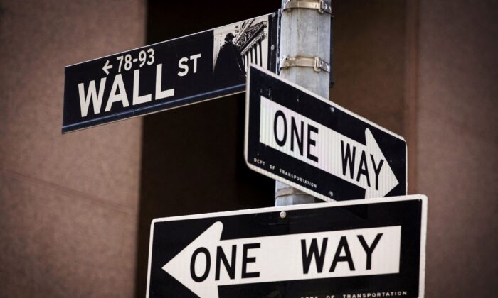 A 'Wall St' sign is seen above two 'One Way' signs in New York, on Aug. 24, 2015. (Lucas Jackson/Reuters)