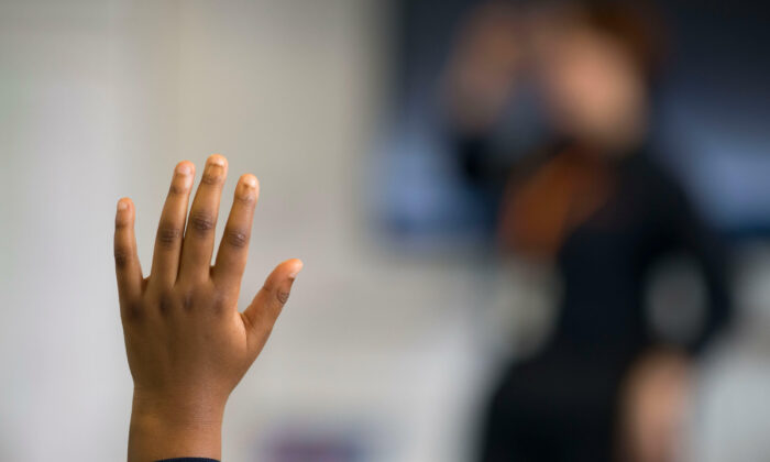 A pupil raises their hand during a lesson at Whitchurch High School in Cardiff, Wales, on Sept. 14, 2021. (Matthew Horwood/Getty Images)
