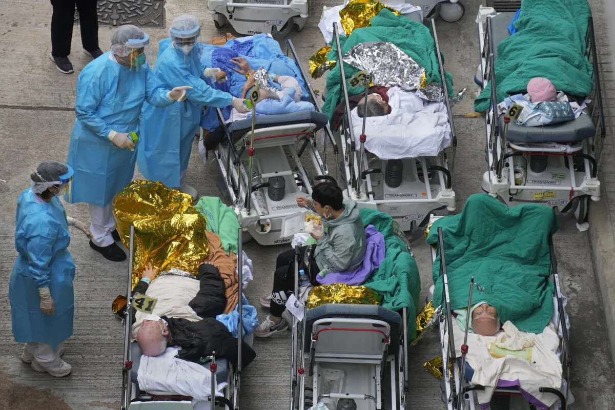 Patients lie on hospital beds as they wait at a temporary holding area outside Caritas Medical Centre in Hong Kong on Feb.16, 2022. (Vincent Yu/AP Photo)