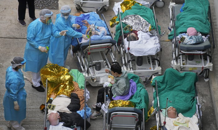 Patients lie on hospital beds at a temporary holding area outside Caritas Medical Centre in Hong Kong, on Feb. 16, 2022. (Vincent Yu/AP Photo)