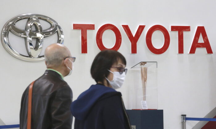 People walk past the logo of Toyota at a showroom in Tokyo, on Oct. 18, 2021. (Koji Sasahara/AP Photo)